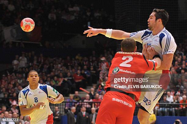 France's Nikola Karabatic passes the ball under the look of teammate and captain Daniel Narcisse on January 30 during the EHF EURO 2010 Handball...