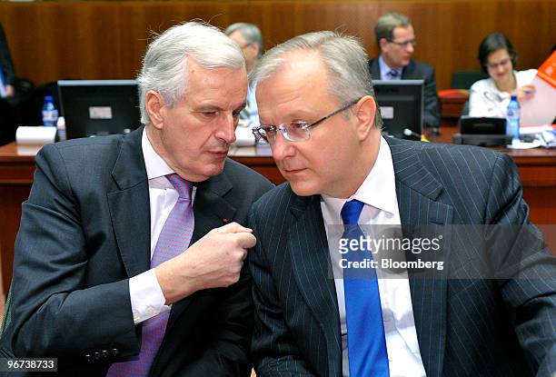Michel Barnier, internal market commissioner for the European Union, left, speaks with Olli Rehn, European Union economic and monetary affairs...