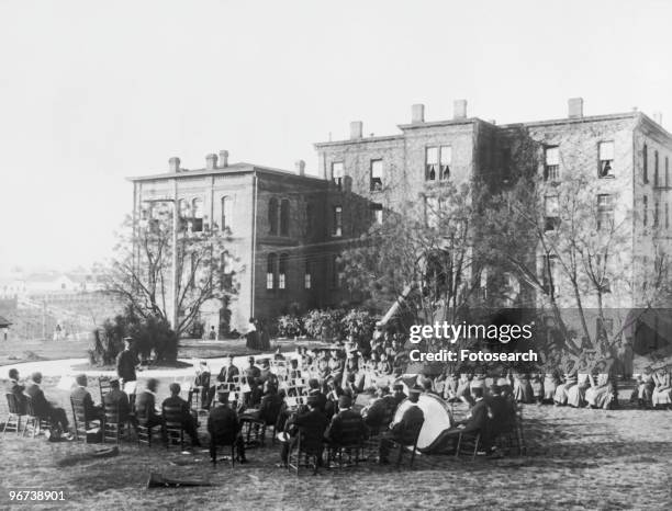 Photograph of band playing outdoors at Tuskegee Institute with building in background circa 1906. .