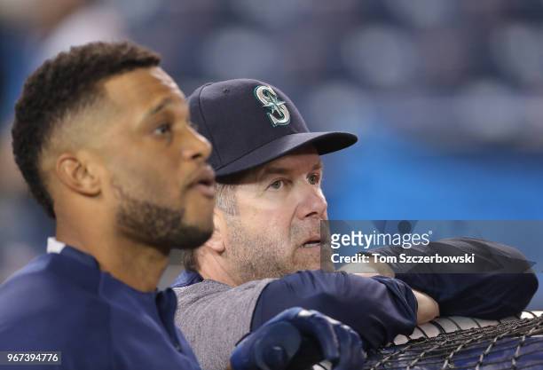Hitting coach Edgar Martinez of the Seattle Mariners and Robinson Cano look on during batting practice before the start of MLB game action against...