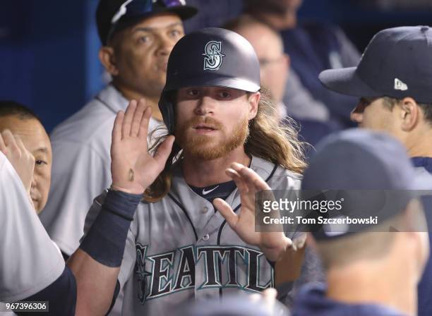 Ben Gamel of the Seattle Mariners is congratulated by teammates in the dugout after scoring a run in the third inning during MLB game action against...