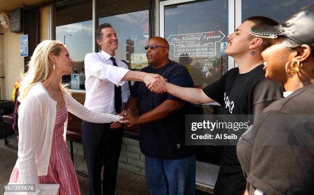 Gavin Newsom with his wife Jennifer Siebel Newsom, left, shake hands with J.C. Johnson, Eric Winner and Kendra Chovan, left to right, as they depart...