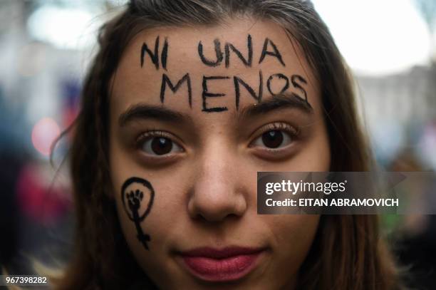 Young woman takes part in a march called by the movement "Ni una menos" against violence against women, and in demand of the right to a safe, free...