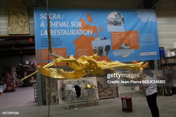 Dorure par Lucie Gohard de la statue de l?archange qui domine l?abbaye du Mont Saint-Michel, 21 avril 2016 à la SOCRA de Marsac-sur-l?Isle en...