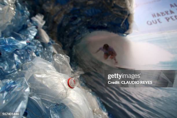 Billboard portraiting a man, surfing a wave made out of plastic bags and bottles, to denounce ocean's pollution is pictured in Santiago on the eve of...