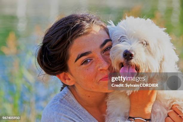 Fille avec un chien Coton de Tuléar.