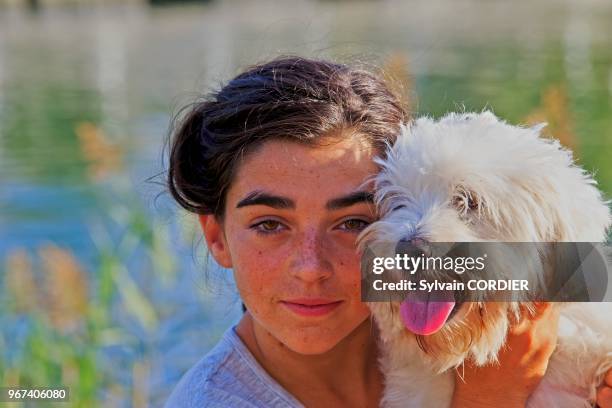 Fille avec un chien Coton de Tuléar.