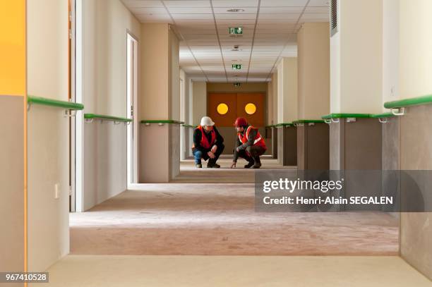 Chantier de construction, verification pour livraison après coulage d'une chape liquide, dans un batiment public hospitalier.