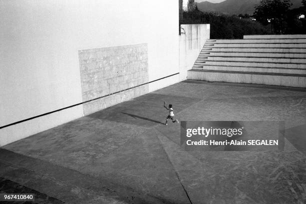 ENFANT SOLITAIRE S'ENTRAINANT A LA PALETA SUR UN FRONTON DE PELOTE BASQUE DANS LA REGION D'ESPELETTE.