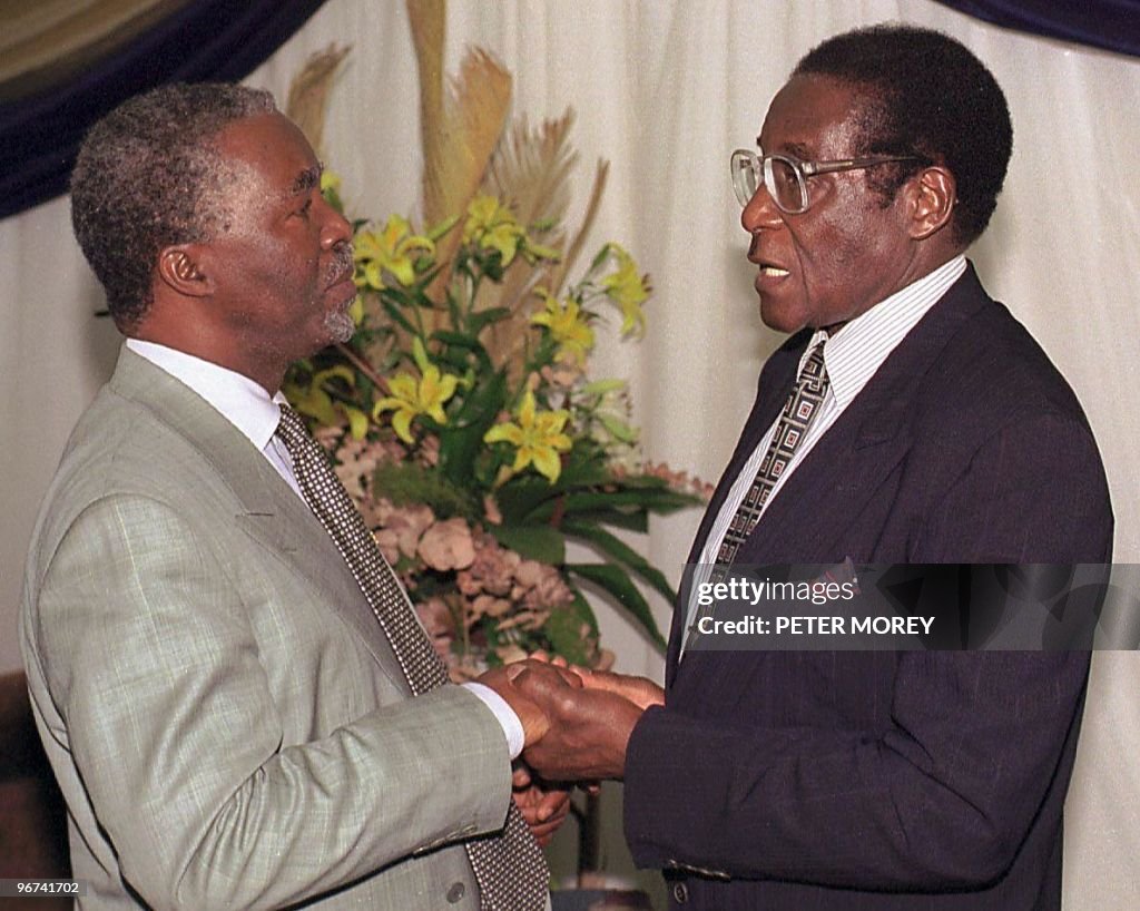 Zimbabwean President Robert Mugabe (R) g