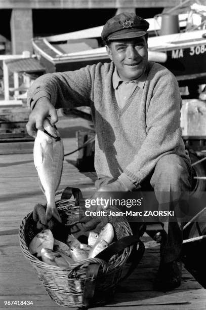 Pêcheur montrant sa pêche, sur le Vieux-Port, à Marseille, en France le 21 octobre 1976.