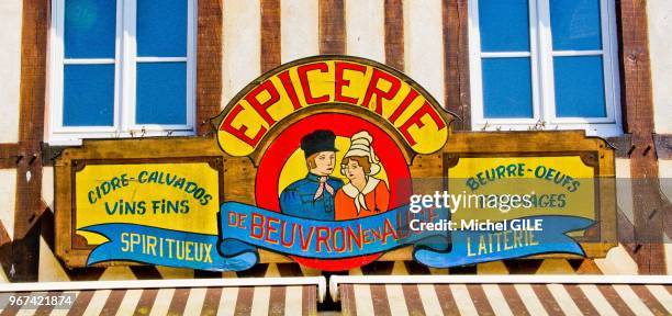 Epicerie typique normande avec enseigne cidre calvados vins fins spiritueux beurre oeufs fromages laiterie, Beuvron en Auge, Calvados, France.