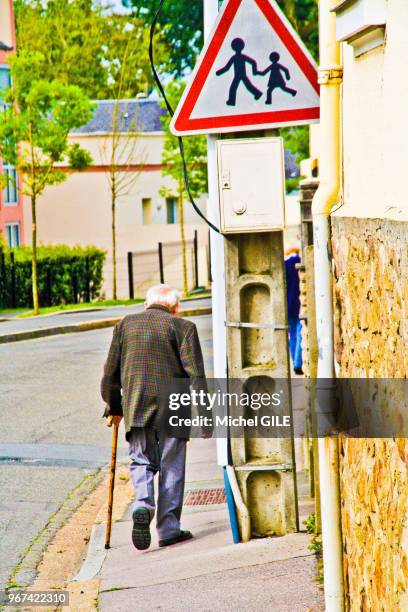 Homme age avec canne, panneau routier attention ecole, Le Mans, Sarthe, France.