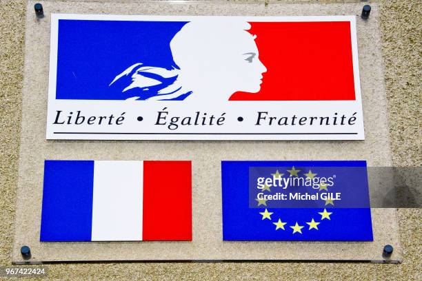Panneaux sur un mur représentant les drapeaux français, européen et devise française 'Liberté, Egalité, Fraternité', Domtfront en champagne.