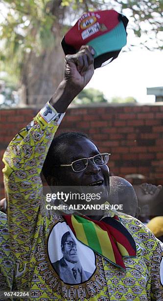Zimbabwean President Robert Mugabe, leader of Zimbabwe's ruling National Africa Union -Patriotic Front waves with his cap as he leaves a rally in...