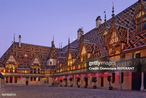 Hotel-Dieu de Beaune, facades sur cour au crepuscule avec la lune au ras de la faitiere, eclairage complet d'un spectacle "son et lumiere",...