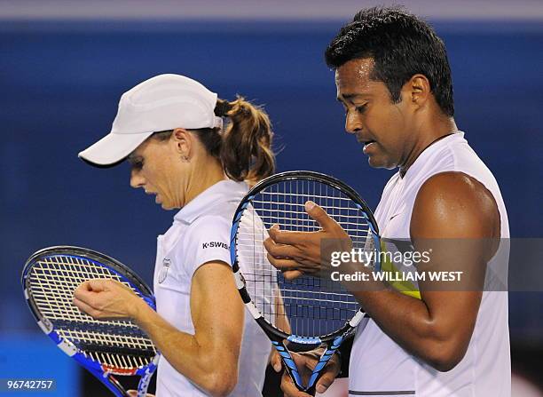 Leander Paes of India and partner Cara Black of Zimbabwe adjust their racket strings while playing against Ekaterina Makarova of Russia and Jaroslav...