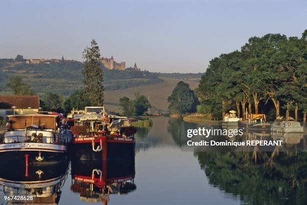 Paysage de Bourgogne, le canal de Bourgogne et la colline de Chateauneuf, village et forteresse medievale, bateaux amarres le long du canal,...