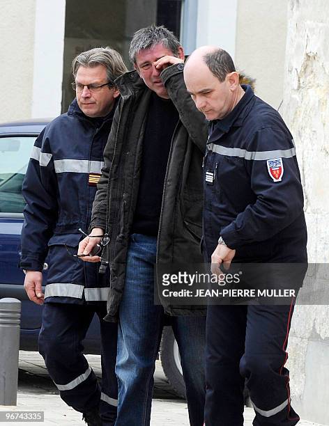 Two firemen accompany a man after announcing him the accident of the bus carrying a French school party, on February 16, 2010 in Riberac, western...