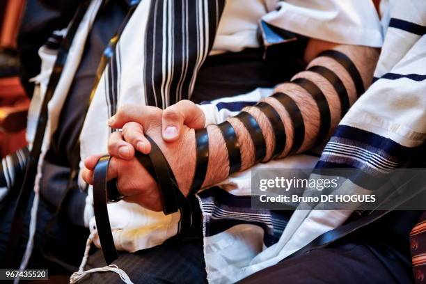 Téfilin porté au bras pendant la prière dans une synagogue.