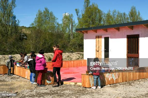 Enfants autour d'une enseignante bénévole lors d'un atelier peinture dans le camp de réfugiés, 28 avril 2016, Grande-Synthe, banlieue de Dunkerque,...