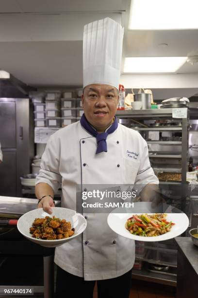 This picture taken on May 17, 2018 shows Ken Chan, the executive chef at the five-star hotel restaurant Le Palais in Taipei, displaying two dishes...