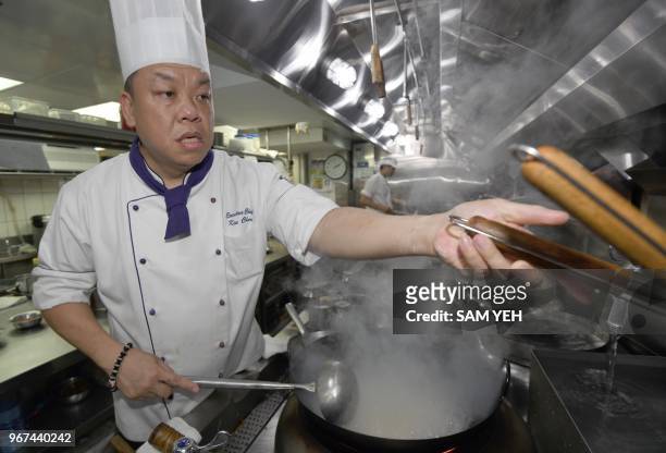 This picture taken on May 17, 2018 shows Ken Chan, the executive chef at the five-star hotel restaurant Le Palais in Taipei, demonstrating his...