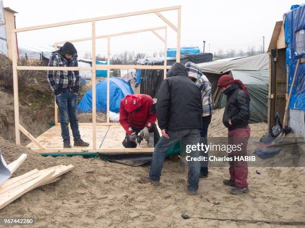 Construction d'un baraquement dans le camp de réfugiés appelé 'jungle' de Calais le 16 février 2016, France. Camp en dur.