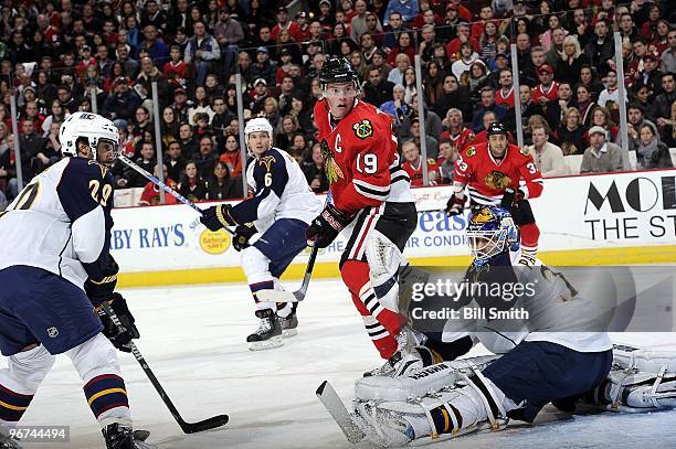 Jonathan Toews of the Chicago Blackhawks looks back toward the puck that flew over goalie Ondrej Pavelec, as Johnny Oduya of the Thrashers waits in...