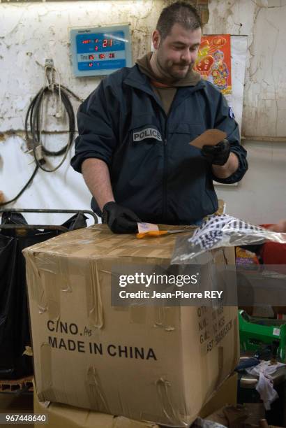 Un policier dans un atelier de confection à Saint Denis le 22 février 2007, France.