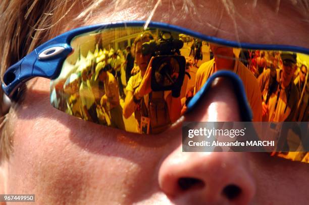 Le reflet des medias dans les lunettes du coureur Axel Merckxx.