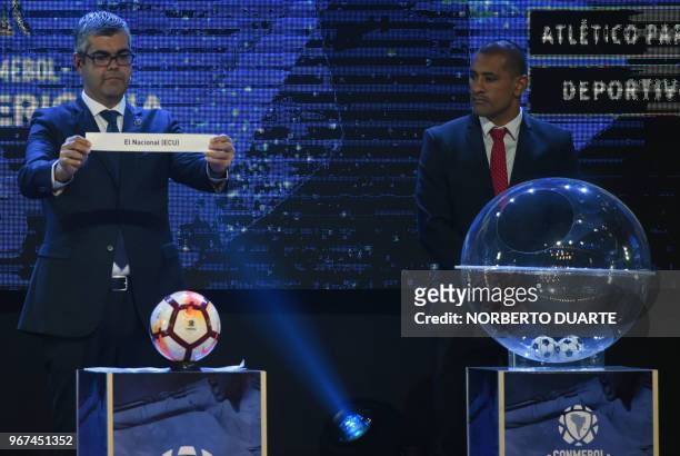 Conmebol Competitions' director Frederico Nantes , next to Paraguayan player Paulo Da Silva, shows the name of Ecuadoran team El Nacional, during the...