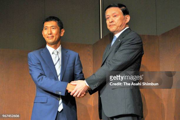 Toshiba Memory President Yasuo Naruke and Bain Capital Japan chief Yuji Sugimoto shake hands during a press conference on June 4, 2018 in Tokyo,...