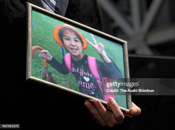 Le Anh Hao holds a portrait of slaying of his daughter, Le Thi Nhat Linh at the Chiba District Court for the opening day of the trial on June 4, 2018...