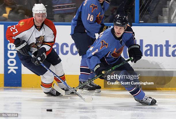 Colby Armstrong of the Atlanta Thrashers carries the puck against Steve Reinprecht of the Florida Panthers at Philips Arena on February 6, 2010 in...