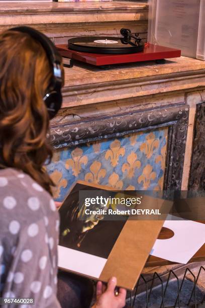 Jeune femme avec un casque écoutant un album sur un tourne-disque lors de la journée du 'Disquaire Day' le 19 avril 2015, Lyon, France.