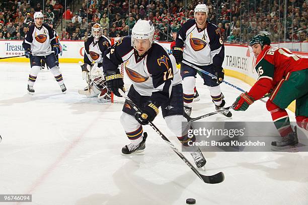 Todd White of the Atlanta Thrashers handles the puck while Andrew Brunette of the Minnesota Wild defends during the game at the Xcel Energy Center on...