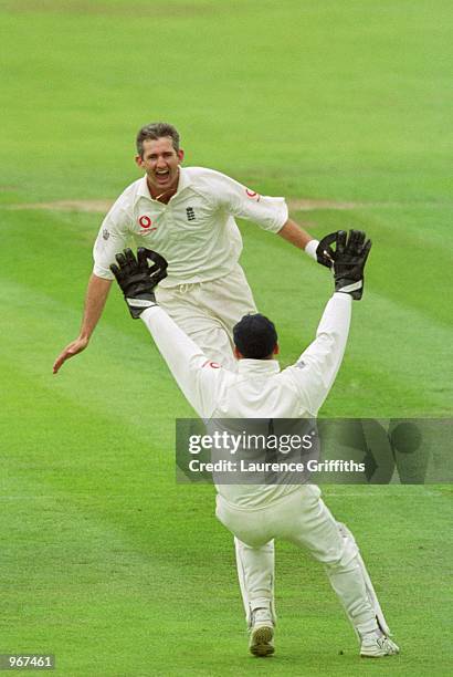 Andrew Caddick celebrates with Alec Stewart of England after he took the wicket of Curtly Ambrose of the West Indies during the Fourth Test match...