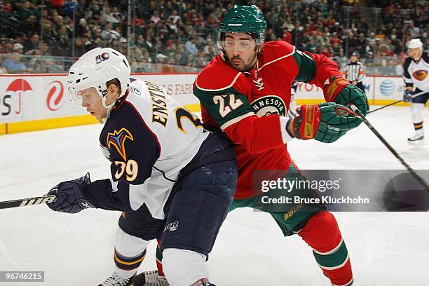 Cal Clutterbuck of the Minnesota Wild and Tobias Enstrom of the Atlanta Thrashers battle for a loose puck during the game at the Xcel Energy Center...