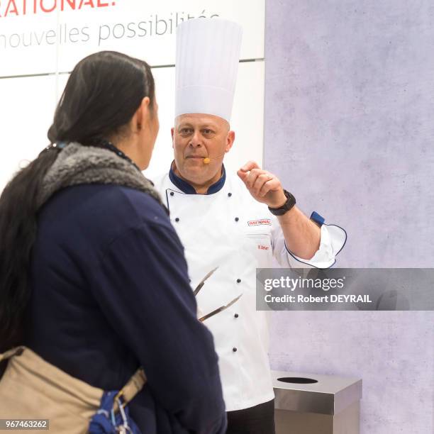 Le chef cuisinier Fabrice Amari échangeant avec une visiteuse lors du 30 ème Salon International de la Restauration de l'Hotelerie et de...