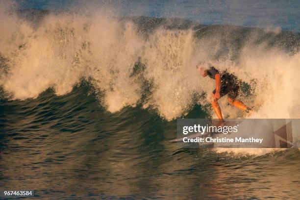surfer catching waves in the afternoon sunshine. - ireland surf wave stockfoto's en -beelden