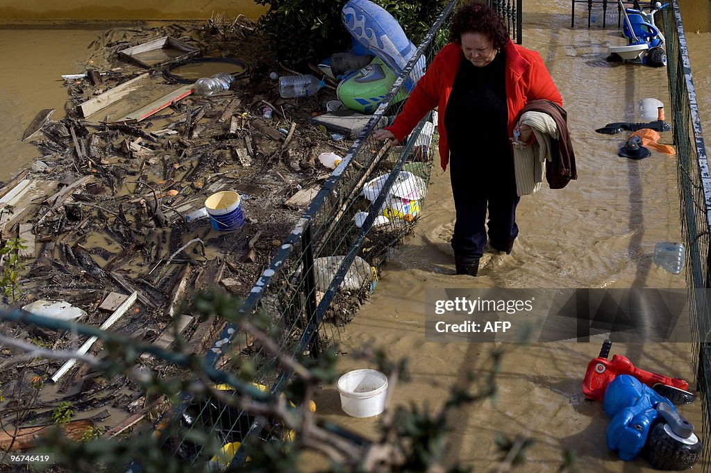 A woman leaves her flooded home in Alhau
