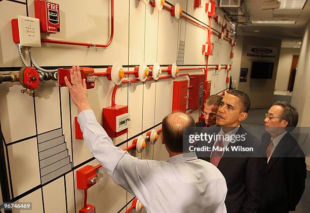 President Barack Obama and Energy Secretary Steven Chu get a tour of a fire alarm panel from teacher Rhett Roe during a visit to the jobs training...