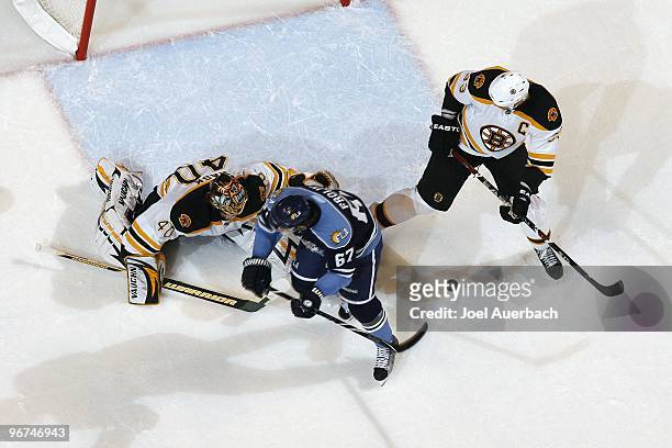 Goaltender Tuukka Rask of the Boston Bruins stops a shot with Michael Frolik of the Florida Panthers waiting outside the crease for a rebound on...