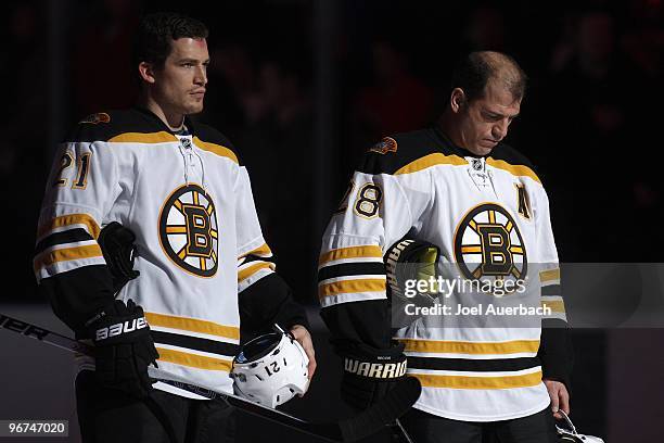 Andrew Ference and Mark Recchi of the Boston Bruins stand at the blue line during the playing of the national anthem prior to the game against the...