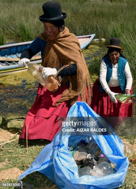 Aymara indigenous women, clean the shore of the Titicaca lake in Puerto Perez, La Paz department, Bolivia on April 18, 2018. - Una decena de mujeres...
