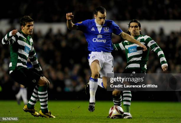 Leon Osman of Everton skips past Pedro Mendes of Sporting Lisbon during the UEFA Europa League Round 32 first leg match between Everton and Sporting...