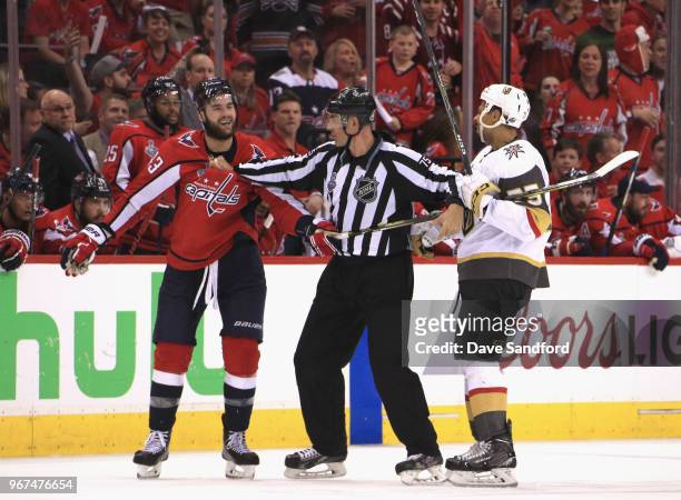 Ryan Reaves of the Vegas Golden Knights and Tom Wilson of the Washington Capitals get in a scuffle as linesman Derek Amell intervenes during the...