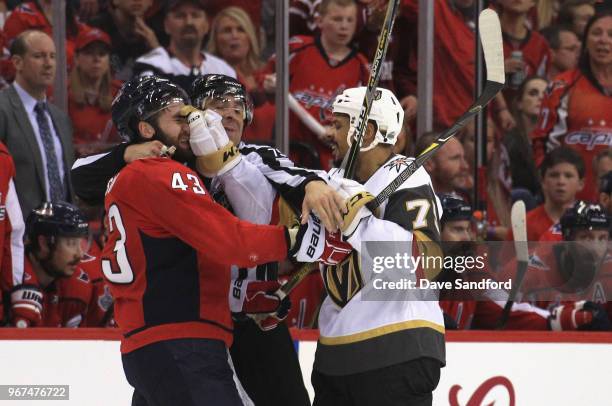 Ryan Reaves of the Vegas Golden Knights and Tom Wilson of the Washington Capitals get in a scuffle as linesman Derek Amell intervenes during the...