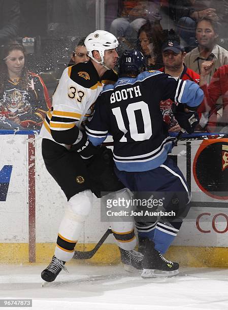 Zdeno Chara of the Boston Bruins checks David Booth of the Florida Panthers in the corner on February 13, 2010 at the BankAtlantic Center in Sunrise,...